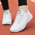 Women's white high-top flat shoes with back lacing and cross strap detail on a PU upper.