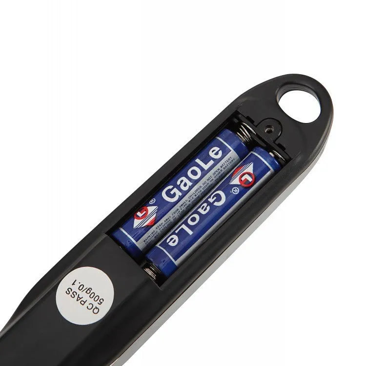 Black digital measuring spoon with LCD display showing weight measurement for kitchen use