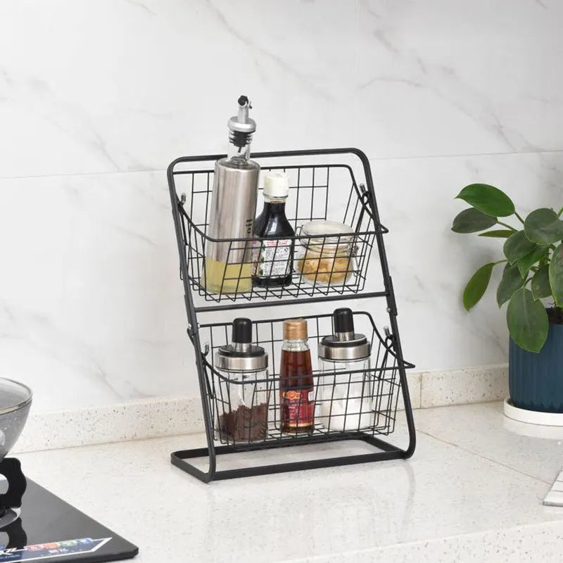 Two-tier black stainless steel kitchen storage rack with fruit and vegetables on a countertop