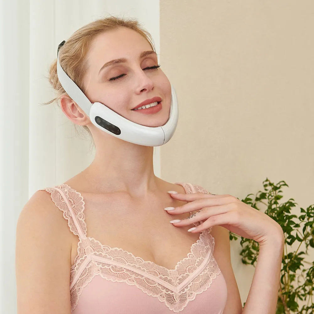 Micro-current IPL facial lifting massager in pink with six modes, adjustable V angle, and USB charging cable