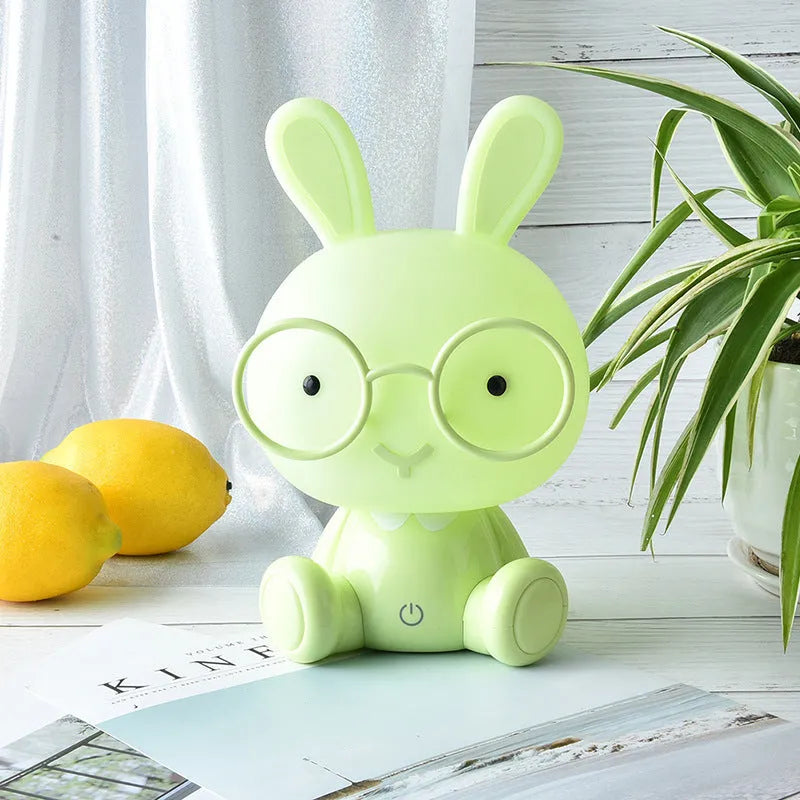 Blue cartoon rabbit-shaped USB night light with glasses on a table