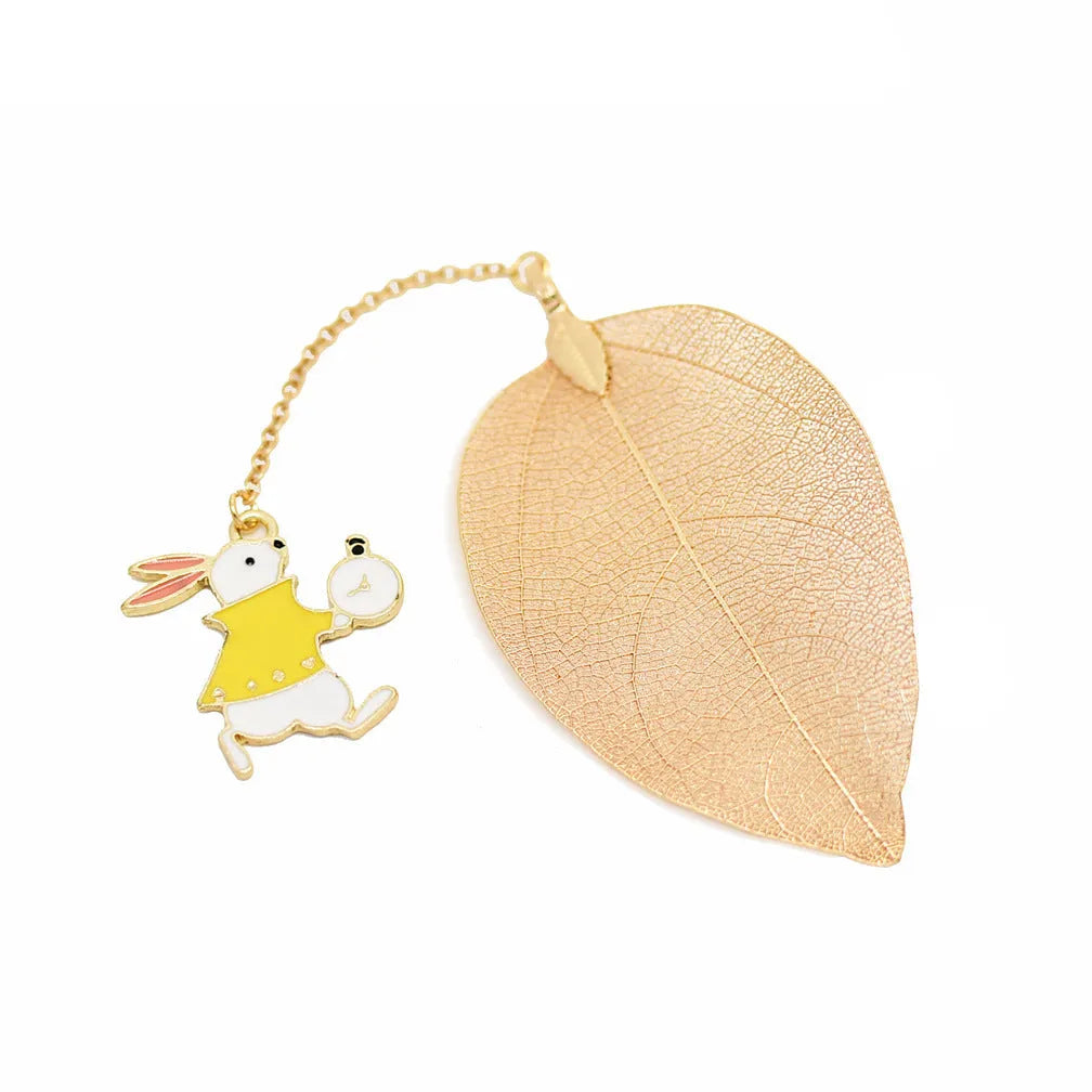 Metal leaf-shaped bookmark with a choice of Alice, rabbit, or clock charm designs on kraft card.
