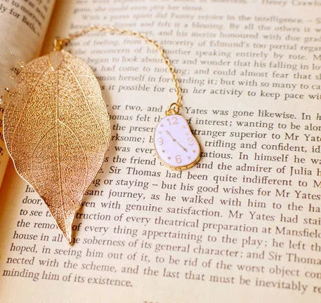 Metal leaf-shaped bookmark with a choice of Alice, rabbit, or clock charm designs on kraft card.