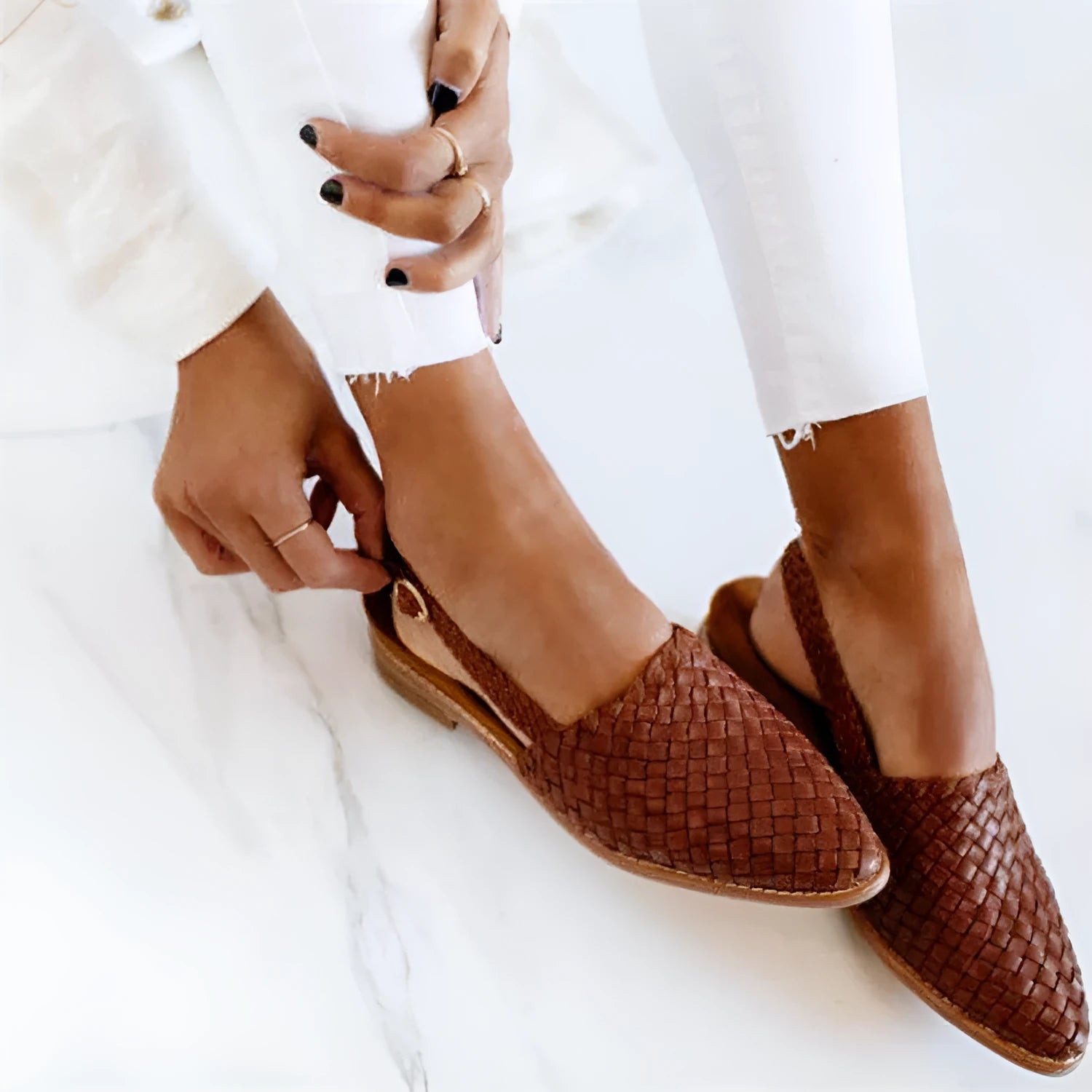 Women's black flat sandals with a buckle fastening and pointed toe on a rubber sole.