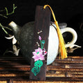 Chinese style painted lotus bookmark made from sandalwood with landscape flower decoration.