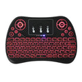 White mini wireless keyboard with colourful backlit keys and included flying squirrel mouse on a desk