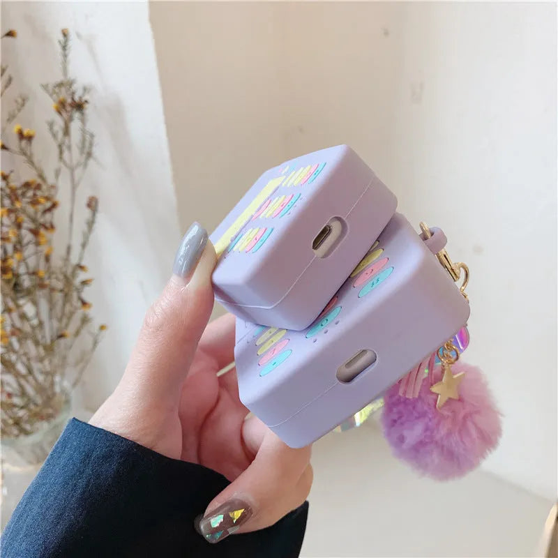 Purple silicone case for Apple AirPods with fur ball pendant showing clamshell design