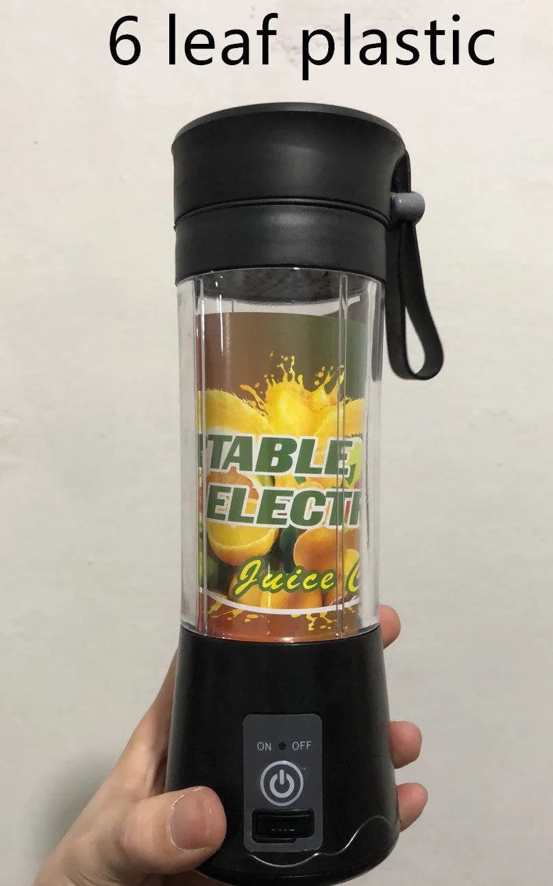 Pink mini USB electric fruit juicer with carrying rope on a kitchen countertop.