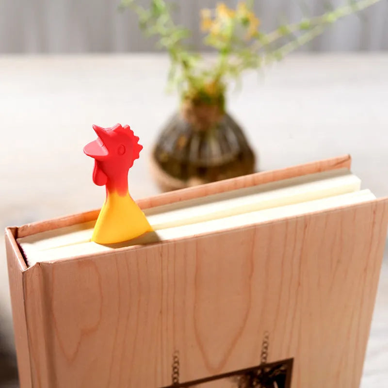 Creative silicone screaming chicken bookmark in yellow on an open book page showing its 16 cm length