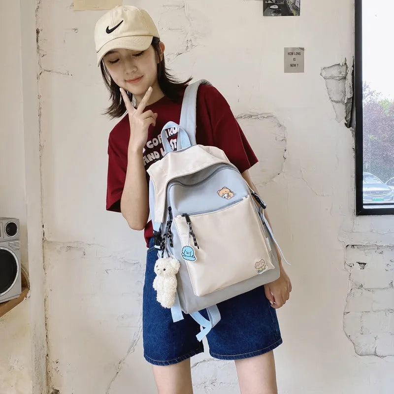 Korean style college backpack in pink without pendant, water repellent, 20-35L capacity on plain background
