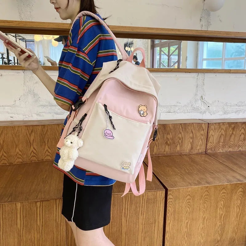Korean style college backpack in pink without pendant, water repellent, 20-35L capacity on plain background