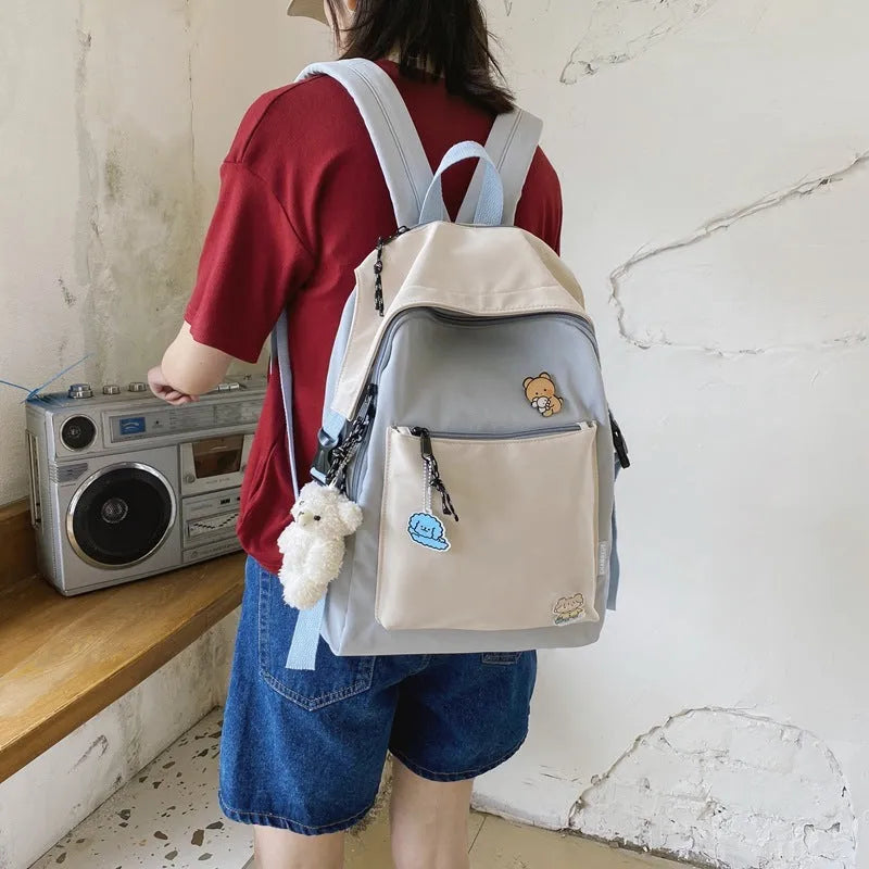 Korean style college backpack in pink without pendant, water repellent, 20-35L capacity on plain background