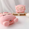 Rose pink silicone AirPods case cover with a cartoon pig in a sweater design and a silver keychain hook.