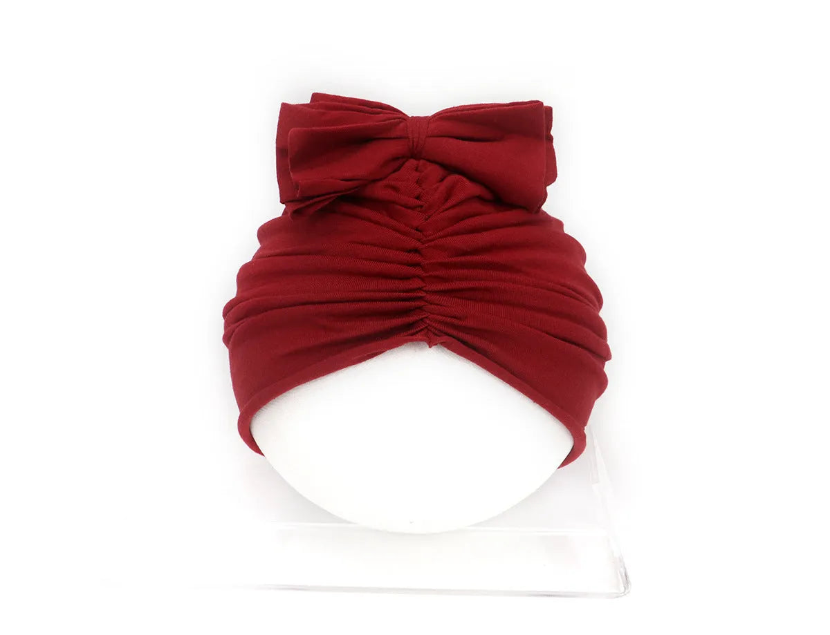 Soft acrylic knitted baby hat in a solid colour, shown on a mannequin head, suitable for newborns and infants.