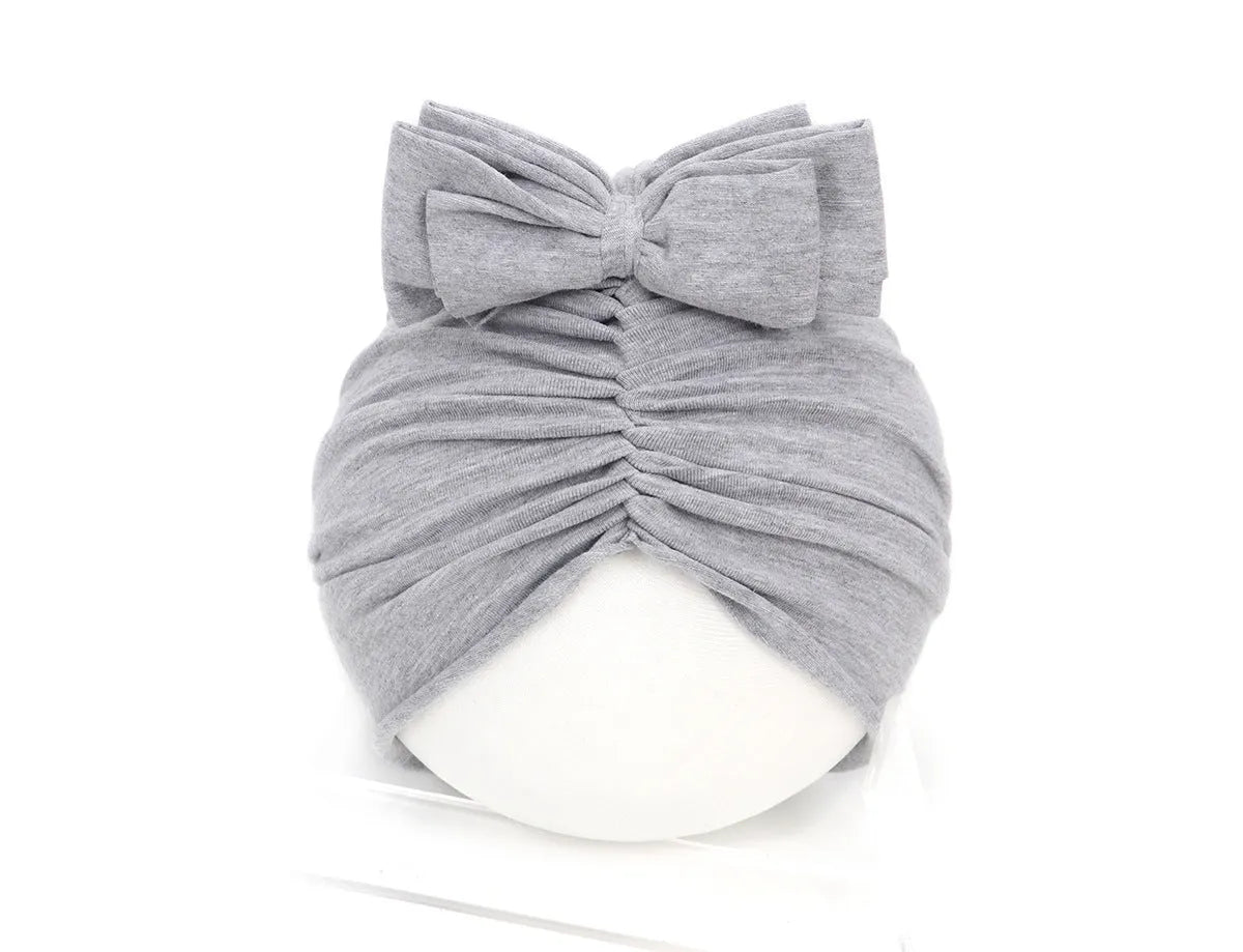 Soft acrylic knitted baby hat in a solid colour, shown on a mannequin head, suitable for newborns and infants.