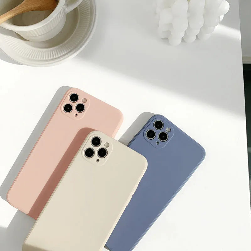 Simple solid colour silicone iPhone case in powder, slate blue or antique white on an iPhone.