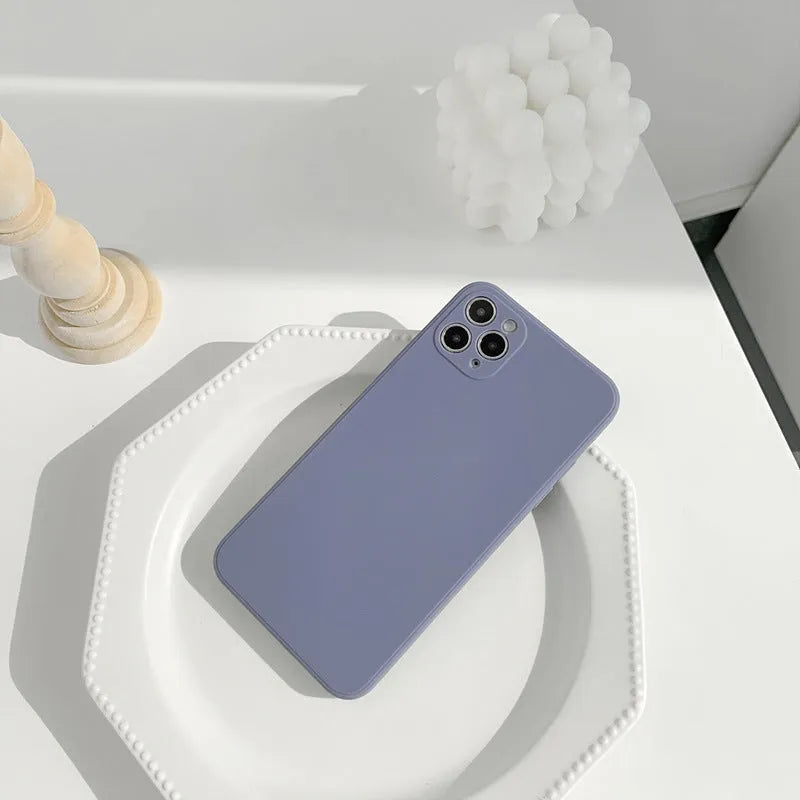 Simple solid colour silicone iPhone case in powder, slate blue or antique white on an iPhone.