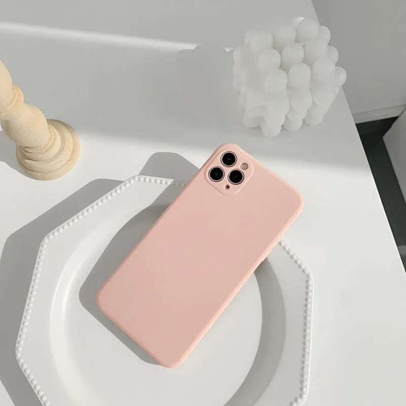 Simple solid colour silicone iPhone case in powder, slate blue or antique white on an iPhone.