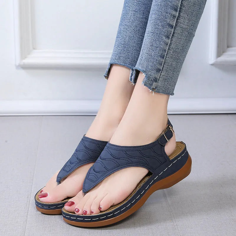 Women's solid colour wedge heel flip flop sandals with an adjustable buckle strap.