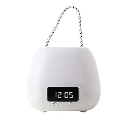 White rechargeable baby night light with remote control and projection function on a bedside table