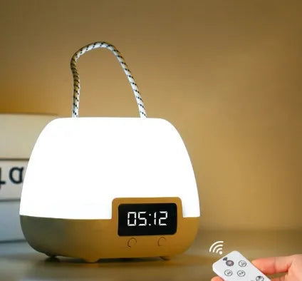 White rechargeable baby night light with remote control and projection function on a bedside table