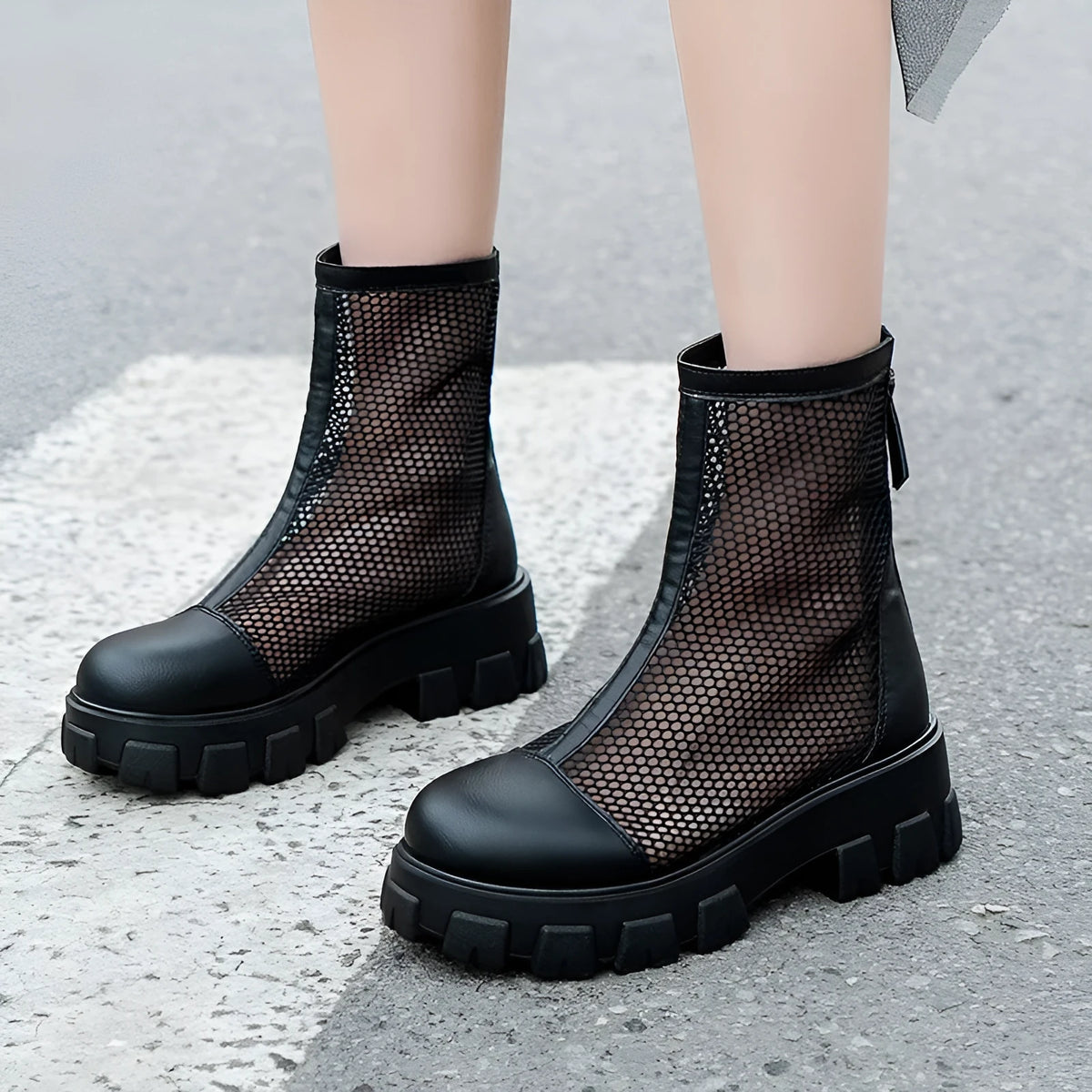 Women's black PU Roman sandals with rear zipper and round toe on a light background, side view.