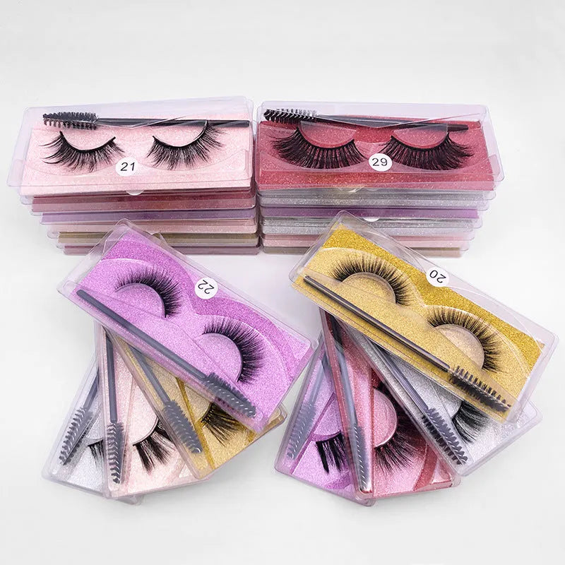 One pair of natural 3D imitation mink false eyelashes in elongated eye tail style with a brush on a white background