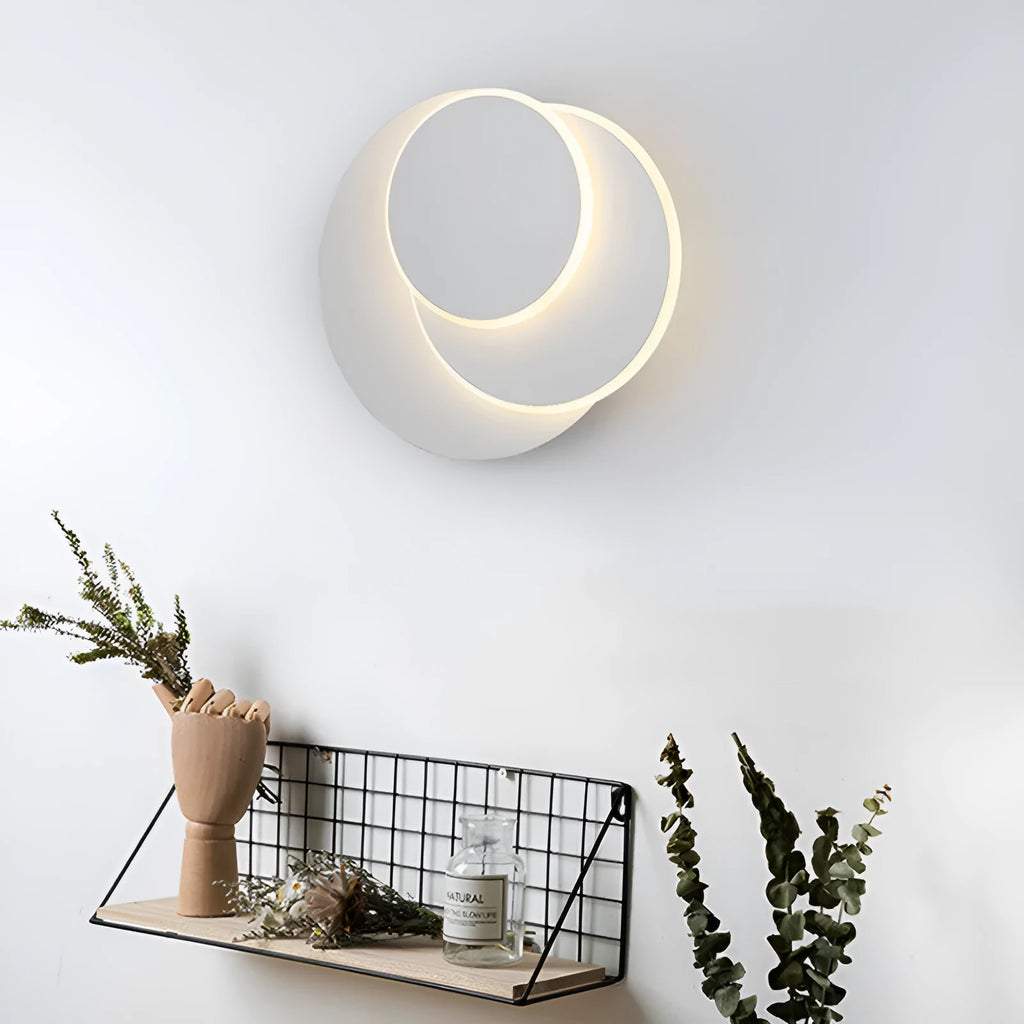Modern round white acrylic LED wall lamp with push button switch mounted on a wall.