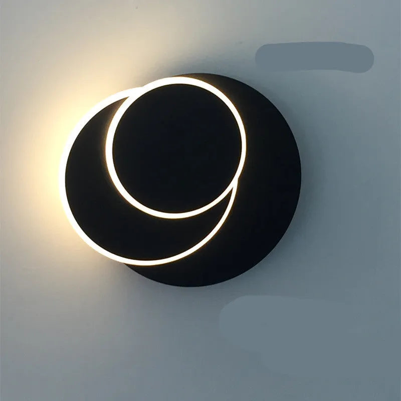 Modern round white acrylic LED wall lamp with push button switch mounted on a wall.