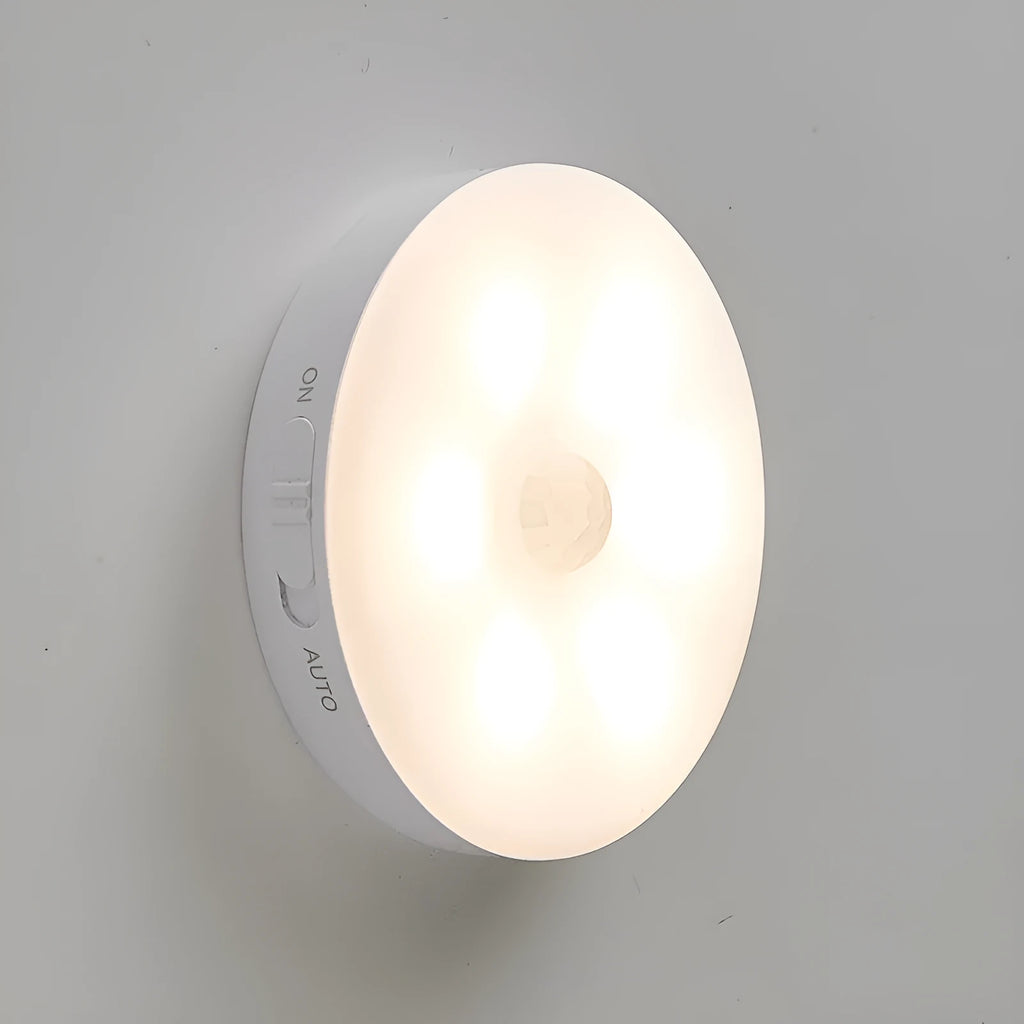 Two small wireless motion-sensor LED night lights placed in a dark hallway.