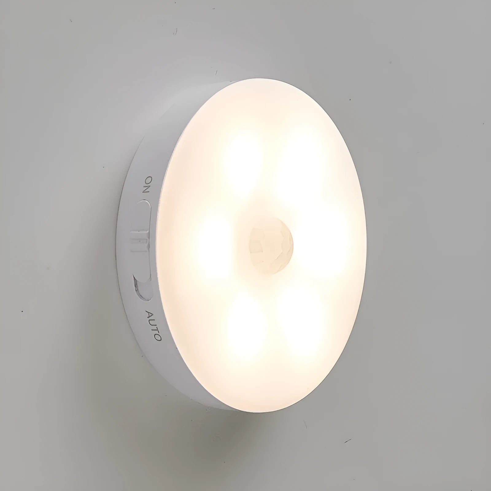 Two small wireless motion-sensor LED night lights placed in a dark hallway.