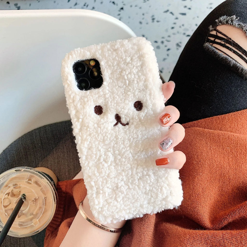 Brown embroidered plush cartoon bear face on a flexible iPhone phone case.