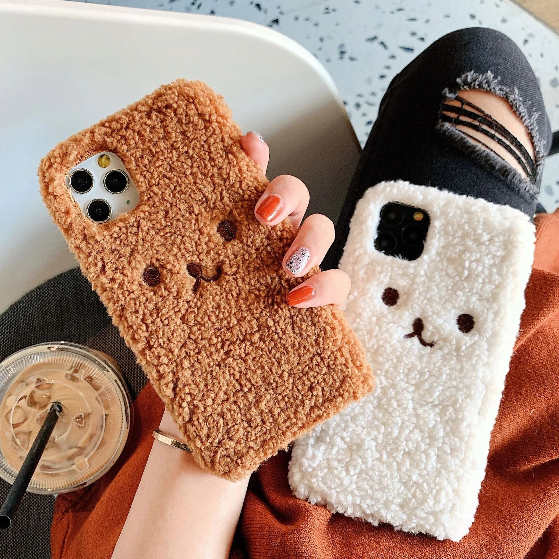 Brown embroidered plush cartoon bear face on a flexible iPhone phone case.