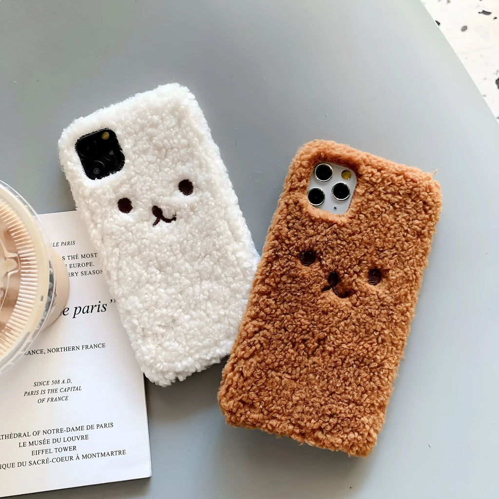 Brown embroidered plush cartoon bear face on a flexible iPhone phone case.