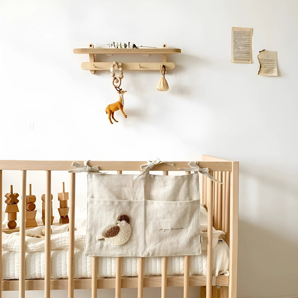 Khaki cotton linen hanging storage bag with multiple pockets mounted beside a bed.