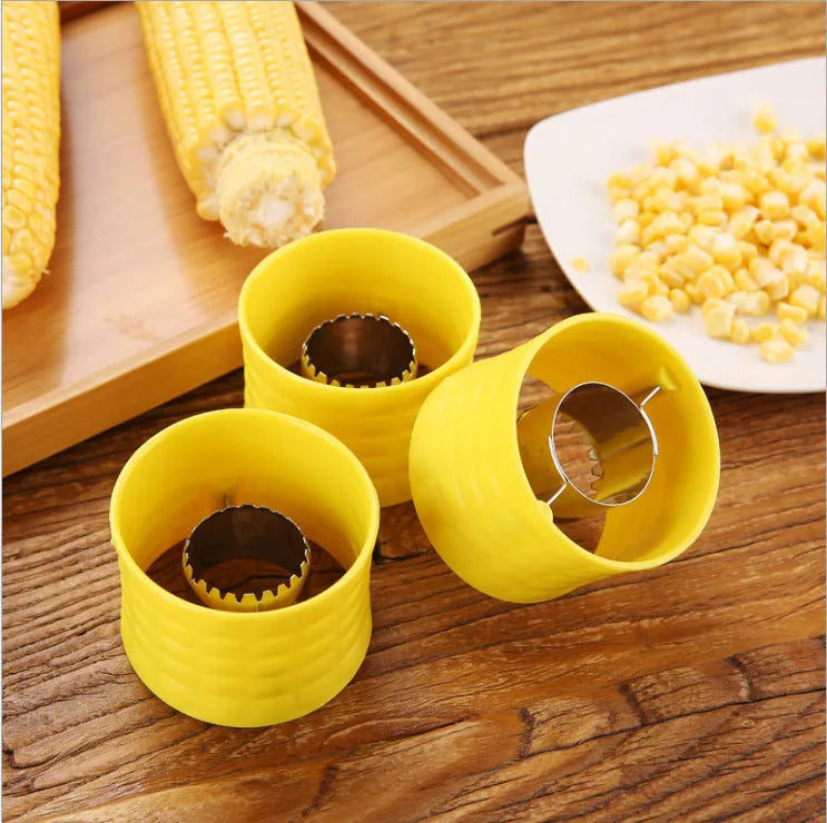 Yellow manual corn grinder thresher kitchen tool with corn-shaped design and stainless steel gear.