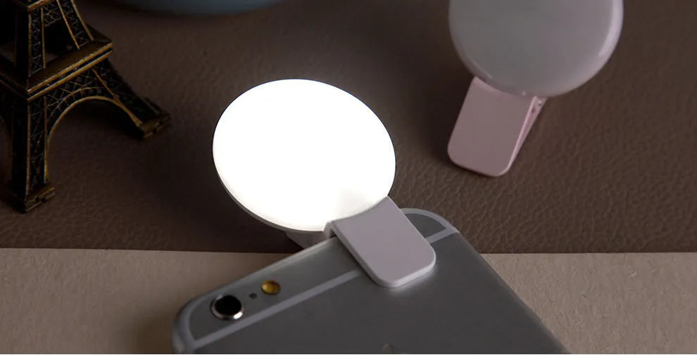 Circular mobile phone selfie ring light attached to smartphone providing frontal illumination