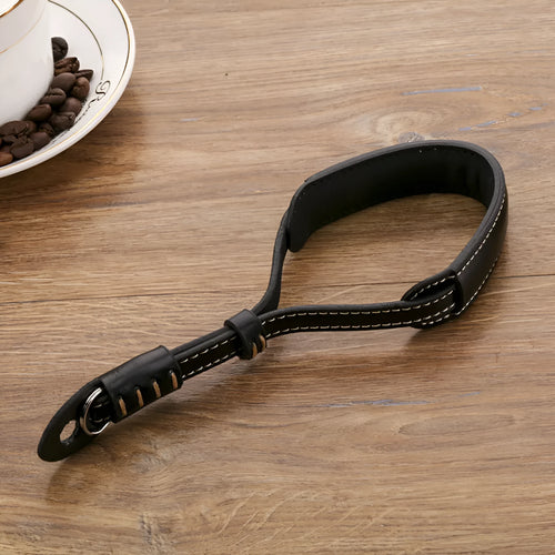 Black leather wrist strap attached to digital camera with small anchor point
