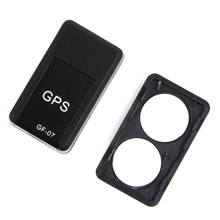Small black plastic magnetic GPS tracker device next to a USB charging cable.