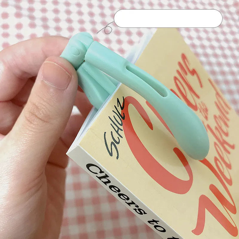Folding book light with night light function in blue, green, pink, or yellow colour options.