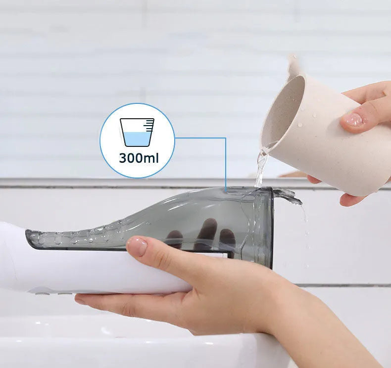 White portable oral irrigator with large water tank and multiple nozzles on a bathroom counter