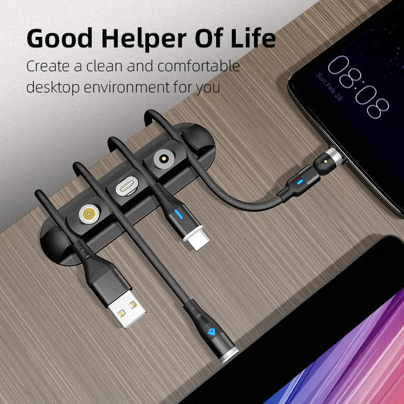 Black soft plastic desktop charging cable organiser on a wooden desk.