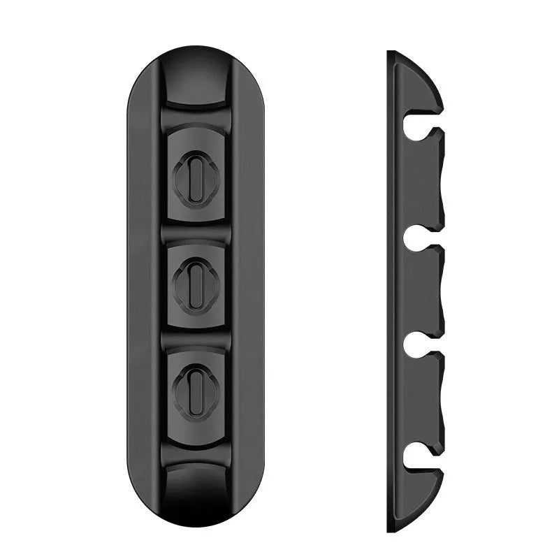 Black soft plastic desktop charging cable organiser on a wooden desk.