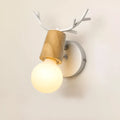 Wrought iron wall lamp with wooden antler-style shade on a white wall