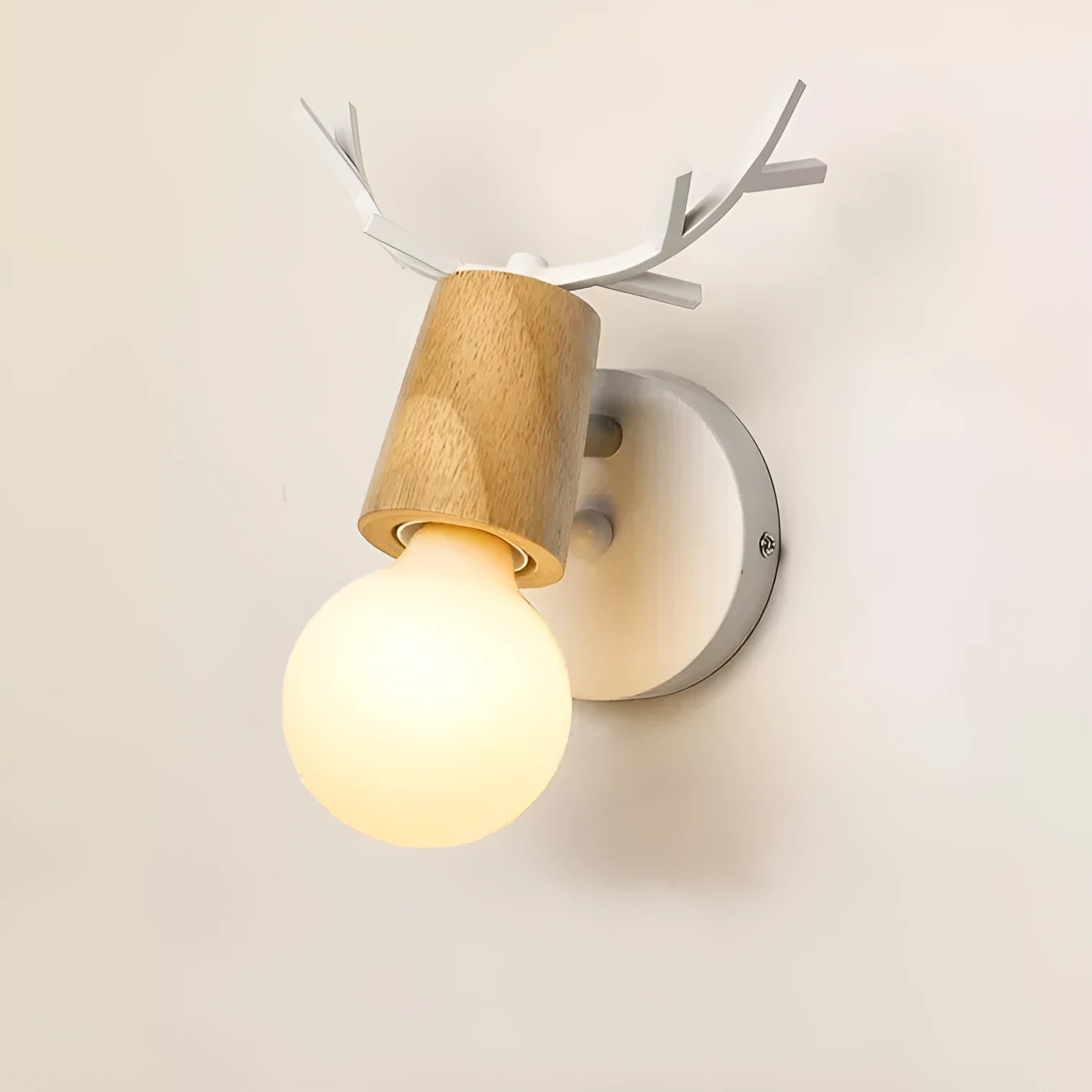 Wrought iron wall lamp with wooden antler-style shade on a white wall