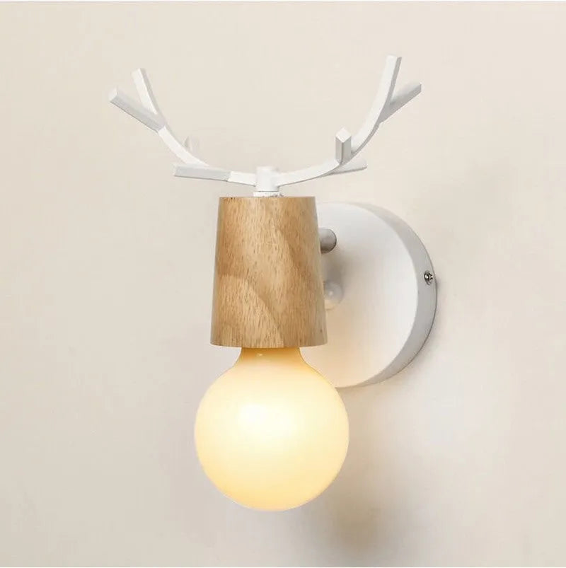 Wrought iron wall lamp with wooden antler-style shade on a white wall