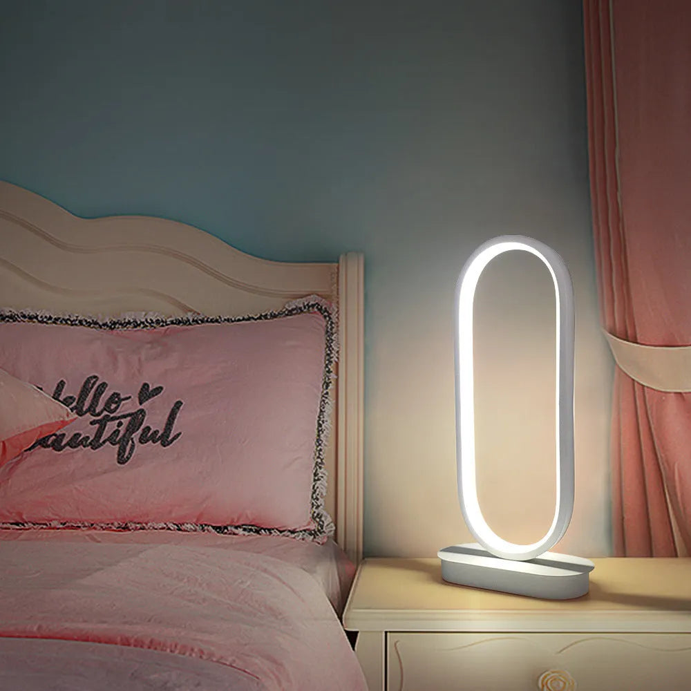 Oval metal table lamp with black finish, LED light, 45cm height, on a wooden surface