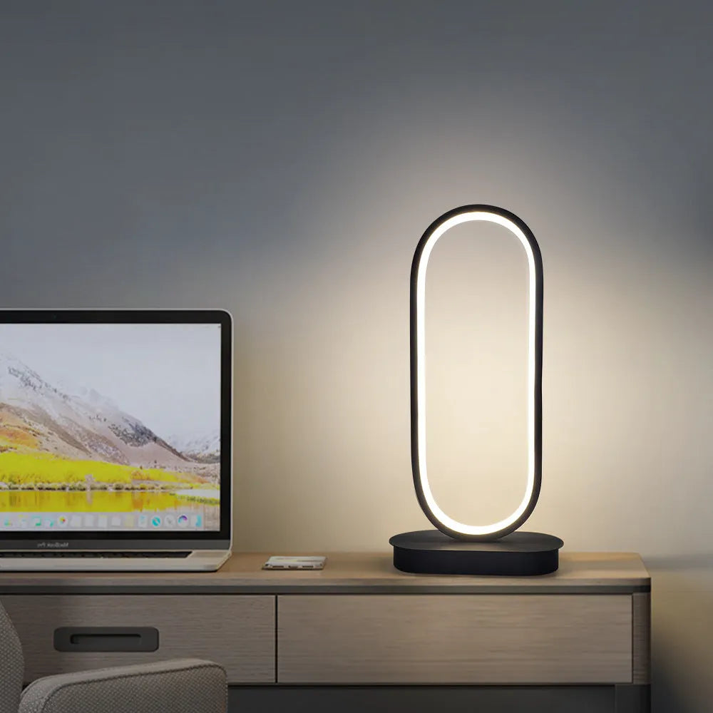 Oval metal table lamp with black finish, LED light, 45cm height, on a wooden surface