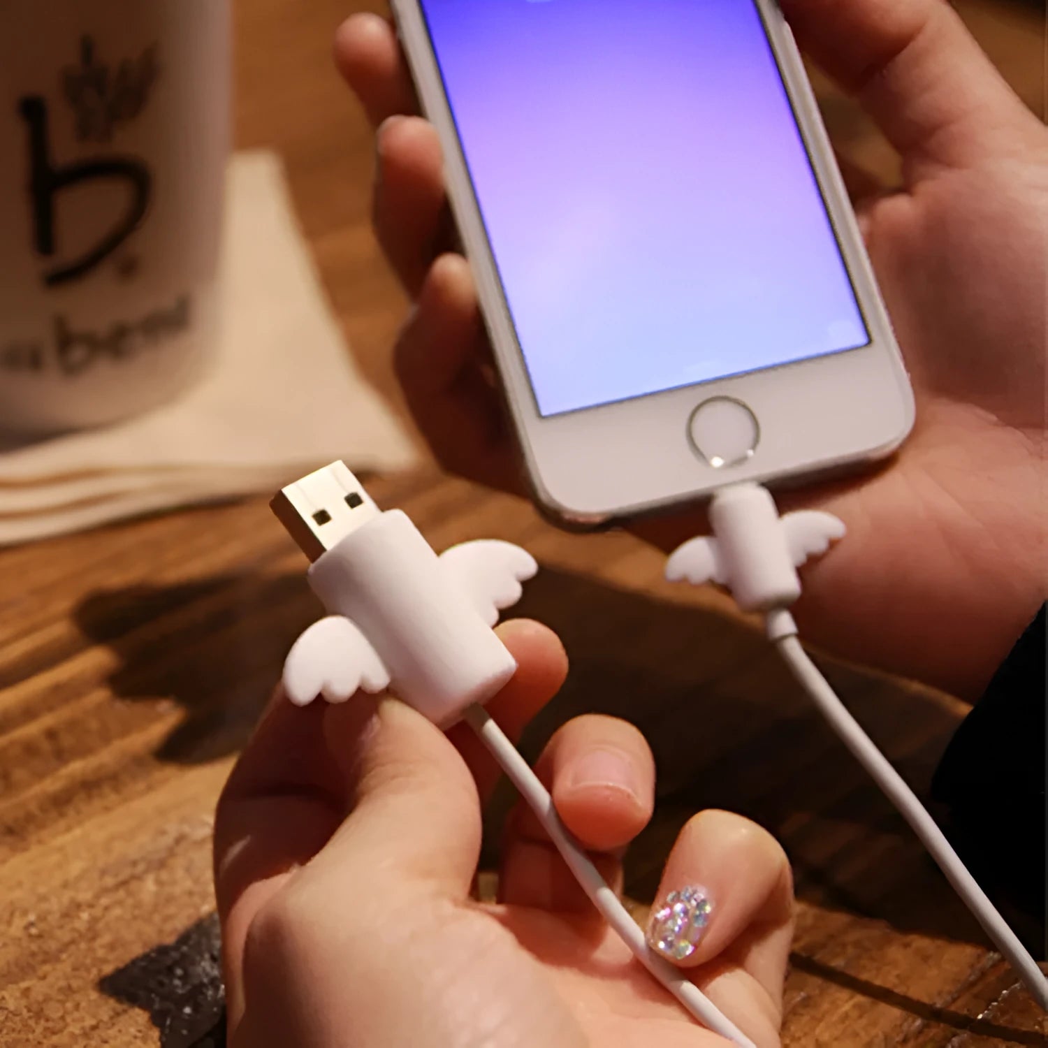 White and black silicone cable protective covers shown next to mobile phone charging cable
