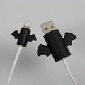 White and black silicone cable protective covers shown next to mobile phone charging cable